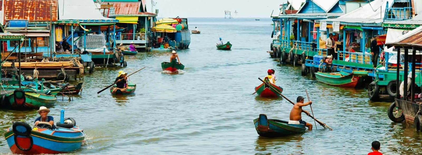 Boat through a floating village at golden hour